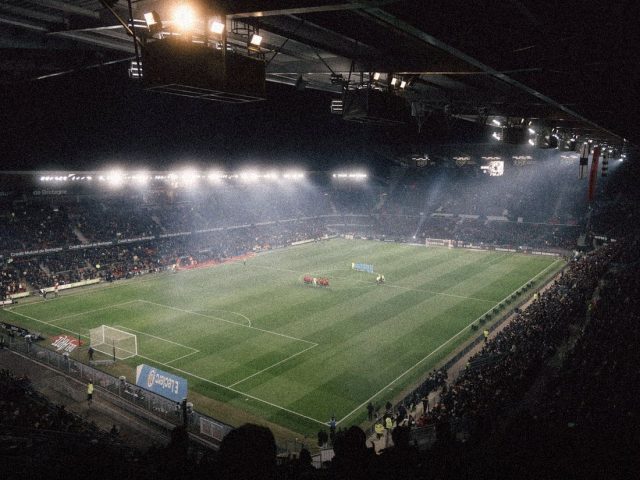 Floodlit football stadium at night, AI betting prediction apps