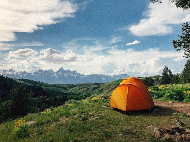 Orange tent on a mountain meadow, best satellite communicators