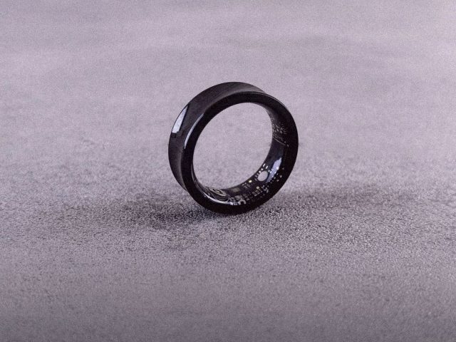 Black smart ring standing on a grey surface, best smart rings