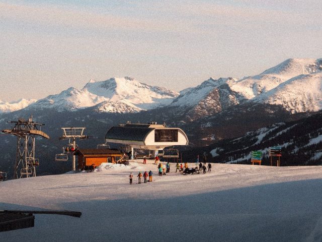 Ski lift station below snowy peaks, winter sports travel insurance