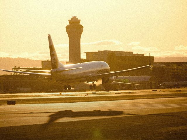 Plane landing at sunset beside the control tower, FlightAware review