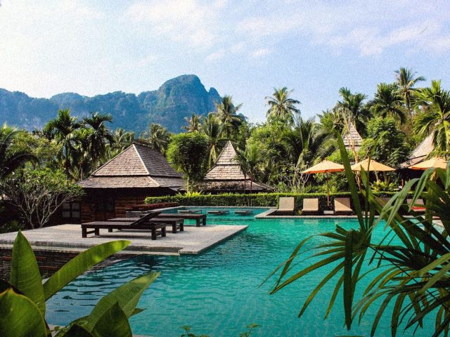 Resort pool with Thai pavilions and limestone hills, longevity retreats in Thailand and Asia