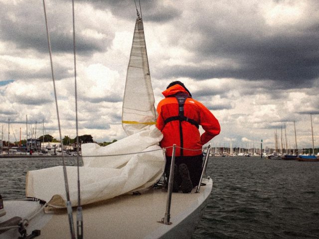 Sailor in an orange lifejacket on a sailing yacht, sailing gear