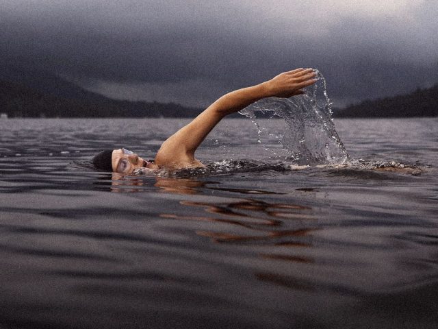 Swimmer doing front crawl in open water, swimming for health