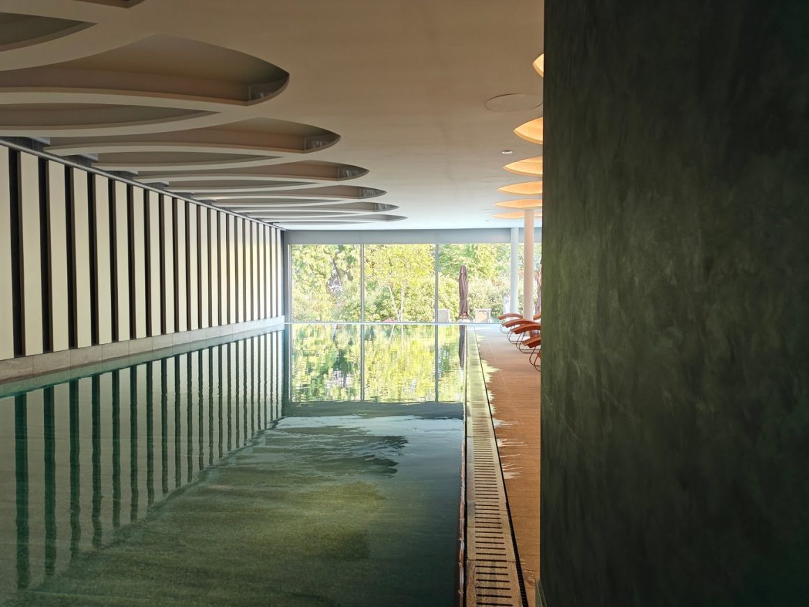 The indoor pool at Chenot Palace Weggis with floor-to-ceiling windows onto the garden